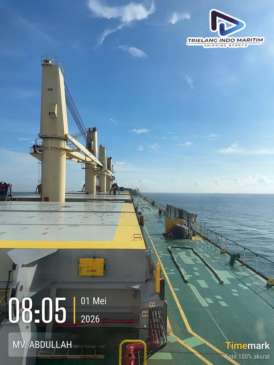 Vessel deck showing closed hatch covers and gantry cranes at sea.